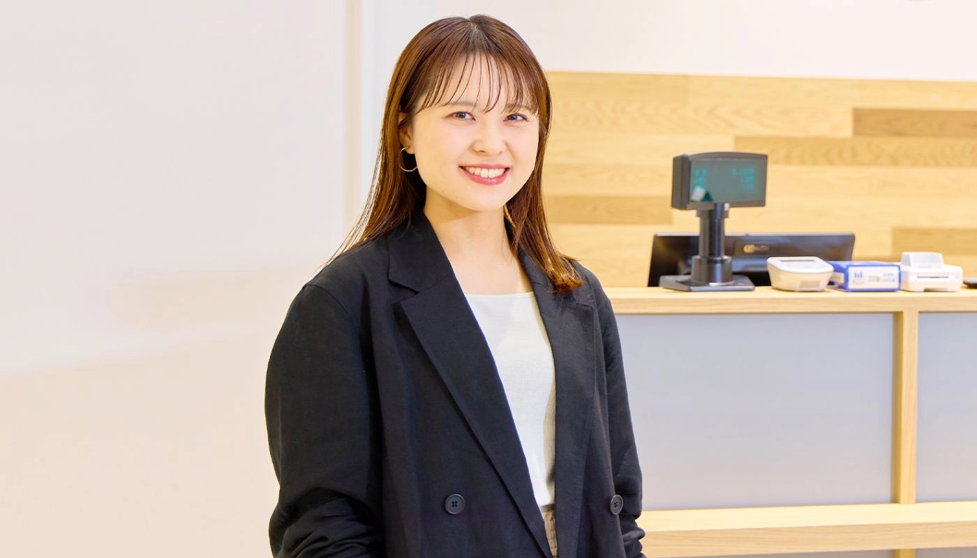 アパレル販売スタッフ（正社員）のH.Y.さんが笑顔で正面を向いている様子