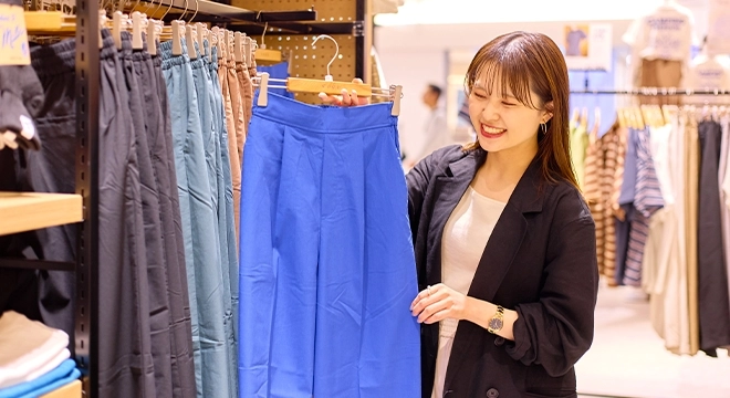 アパレル販売スタッフが商品を案内している様子