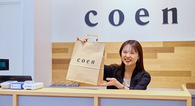 アパレル販売スタッフがお客さまへ商品を渡している様子