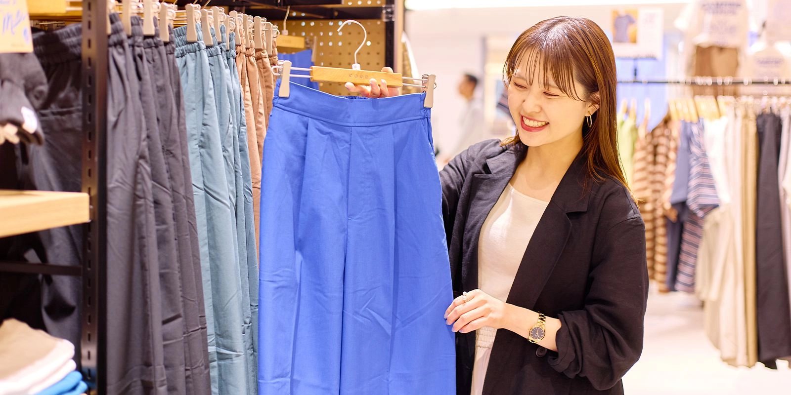 アパレル販売スタッフが商品を案内している様子
