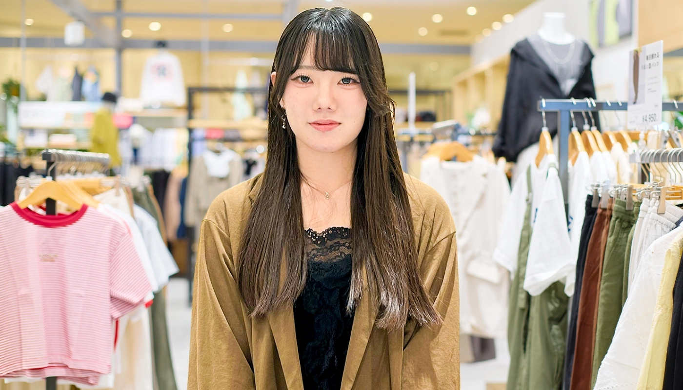 アパレル販売スタッフ（アルバイト・パート）のM.M.さんが笑顔で正面を向いている様子