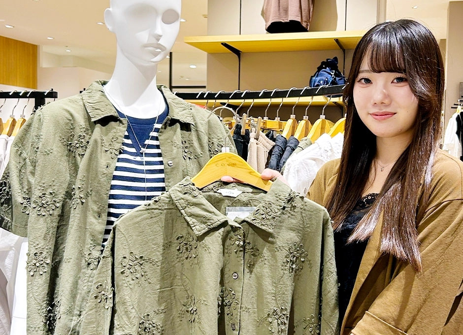 アパレル販売スタッフ（アルバイト・パート）のM.M.さんが商品を案内している様子