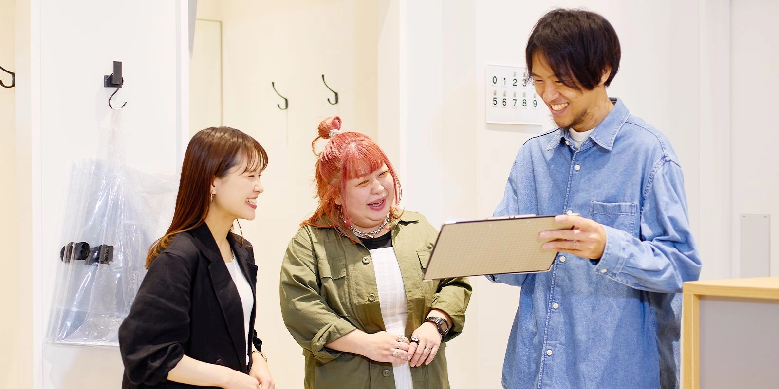 3人のスタッフが笑顔で会話している様子